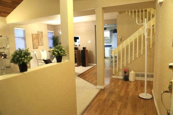 Interior view showing a staircase, hardwood floors, and an open living area with beige walls. - 15425 98th Avenue, Surrey