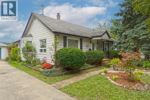 Close-up exterior view of the bungalow's front entrance with a covered porch and manicured landscaping. - 1546 California Avenue, Windsor