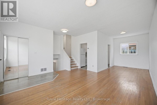 Living room with a sofa, armchair, coffee table, and a window with grey curtains. - 1546 Lakemount Street, Oshawa