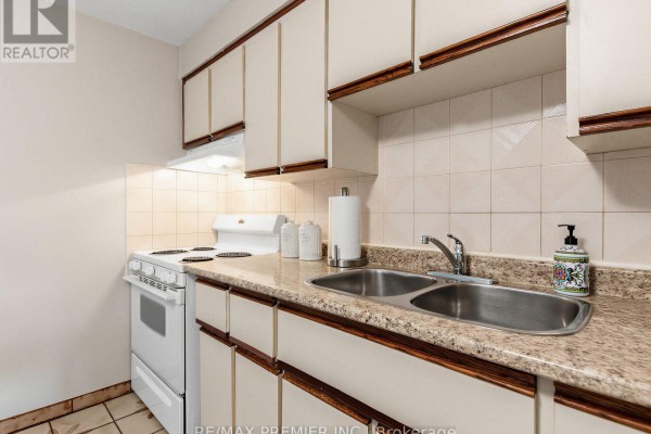 Kitchen with cream cabinets, double sink, and white stove - 155 Ascot Avenue Toronto