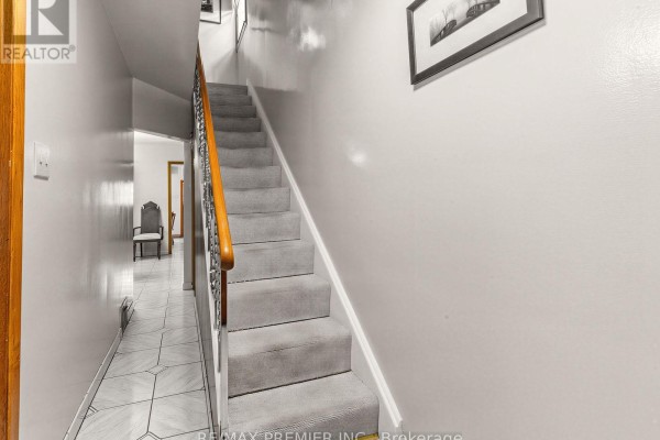 Carpeted stairs with wooden banister and tile hallway - 155 Ascot Avenue Toronto