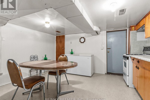 Dining table, freezer, stove, and cabinets in basement kitchen - 155 Ascot Avenue Toronto