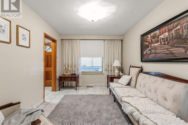 Patterned sofa, rug, artwork, and wooden door in living room - 155 Ascot Avenue Toronto