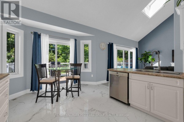 Dining area in the kitchen with a glass-top table, chairs, and large windows overlooking the backyard. - 155 Forest Glen Drive, Gravenhurst)