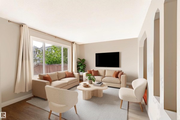 Living room with neutral-toned sofas, chairs, a coffee table, and a large window. - 155 Primrose Gardens Gd Nw, Edmonton