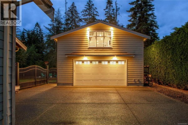 A large backyard with a manicured lawn, a deck, and a detached garage. - 155 Redonda Way, Campbell River