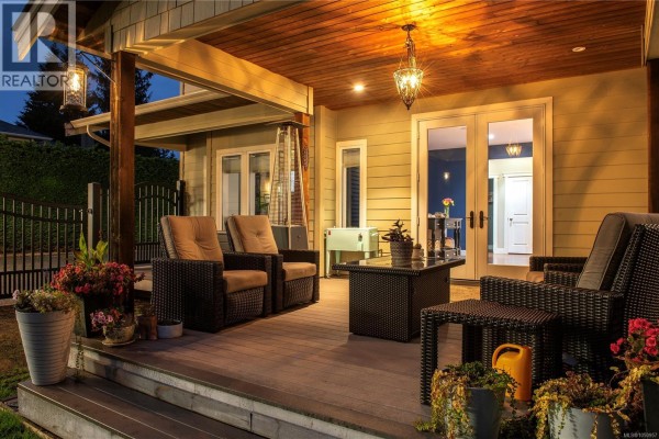 A modern kitchen with white cabinets, a dark wood island, and blue accent walls. - 155 Redonda Way, Campbell River
