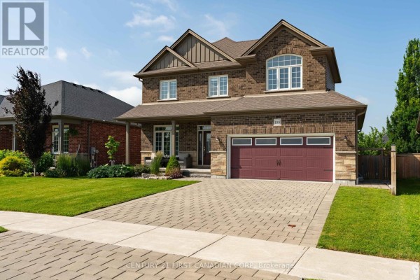 Front exterior view of a brick house with stone accents and a paved driveway. - 155 Spencer Avenue, Lucan Biddulph
