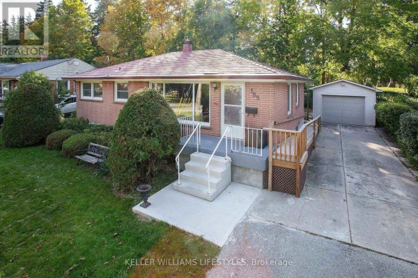 Slightly angled front view of a brick bungalow with a porch, deck, and detached garage. - 155 Trowbridge Avenue, London South
