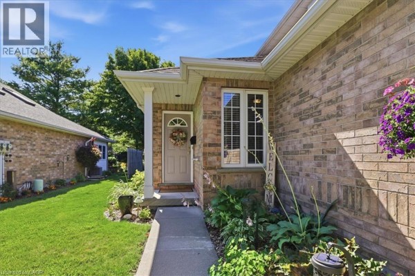 Entrance to a brick townhouse with a beige door and window. - 1550 Gordon Street Unit# 18, Guelph