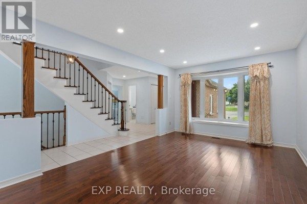 Interior entrance hall with pale blue walls, tiled floor, white door, and a decorative mirror. - 1552 Blohm Drive, Ottawa