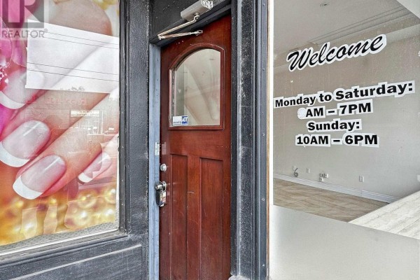 Entrance door with welcome sign and business hours displayed - 1556 Avenue Road, Toronto