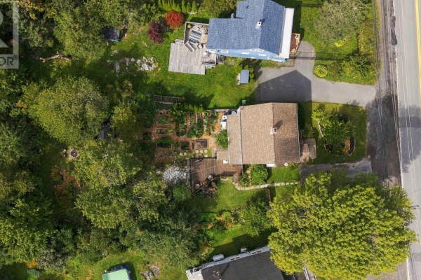 Overhead view of the property, highlighting the house, deck, garden beds, and wooded surroundings. - 1556 St Margarets Bay Road, Lakeside