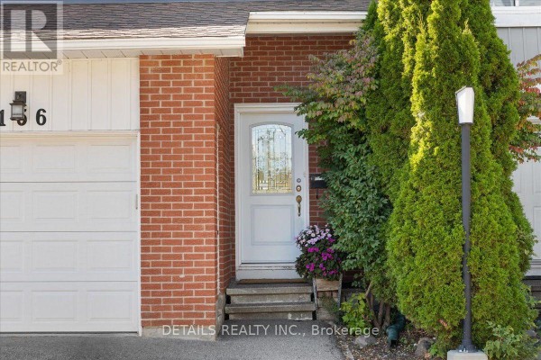 Close-up of front door with glass panels, flanked by brick and trees. - 156 Birch Hill Private N, Ottawa