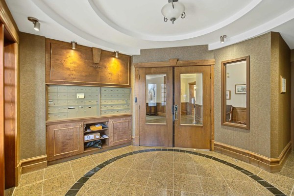 Apartment building lobby with mailboxes, wooden trim, and granite tile floor. - 156 Boul. De Lucerne, #303, Gatineau