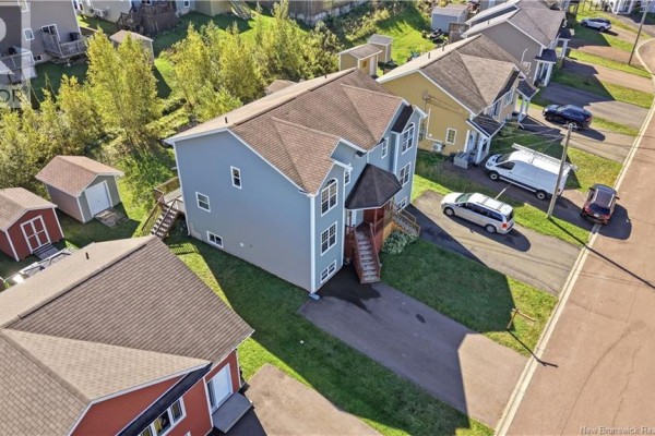 Aerial view of a townhouse complex showing multiple houses, driveways, and trees. - 156 Houlahan Street, Dieppe