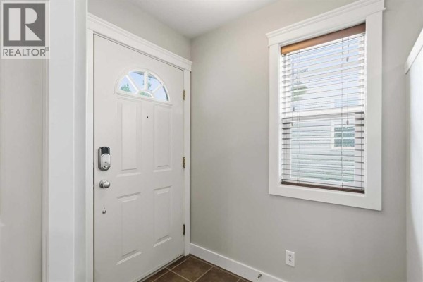 Interior view of a white front door with a decorative window and a small adjacent window. - 156 J.w. Mann Drive, Fort Mcmurray