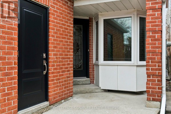 Kitchen with white cabinets, wooden countertop, and a door leading to the backyard. - 156 Macedonia Crescent, Mississauga