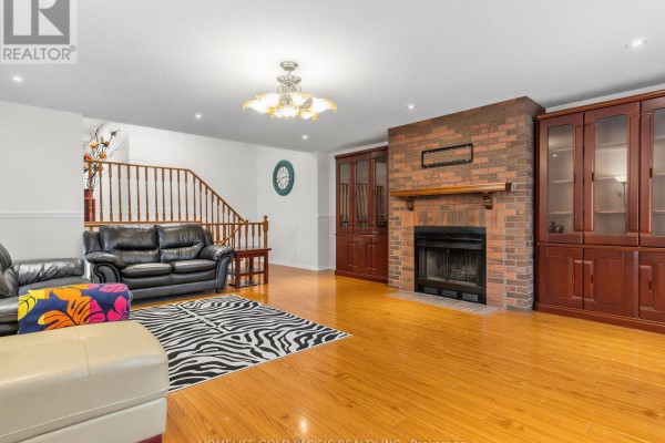 Living room with brick fireplace, built-in cabinets, leather sofas & zebra rug - 156 Ravenscroft Road Ajax