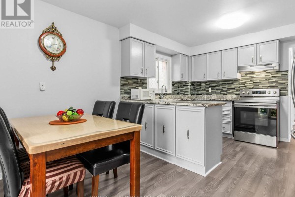 Kitchen with island, dining table, and stainless steel oven - 156 Ravenscroft Road Ajax