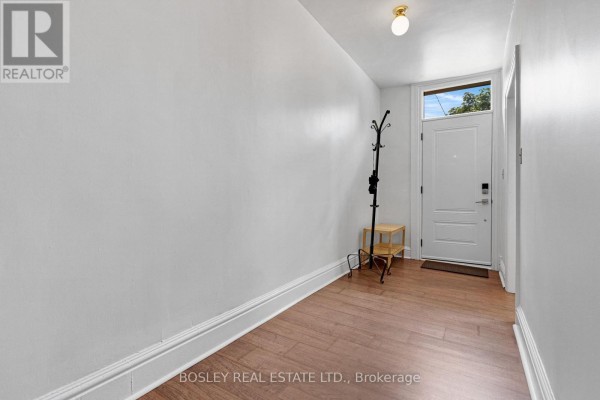 Interior entryway with white walls, hardwood floors, a coat rack, and a glass-paneled door. - 156 St. Andrews Street, Cambridge