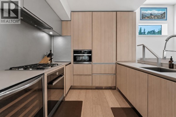 Kitchen with light wood cabinets, stainless steel appliances, and island. - 156 W Woodstock Avenue, Vancouver