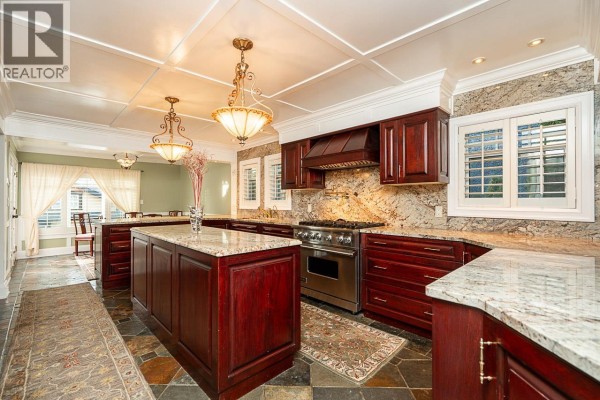 Spacious kitchen with island, pendant lighting, and stone backsplash - 1562 W 62nd Avenue, Vancouver