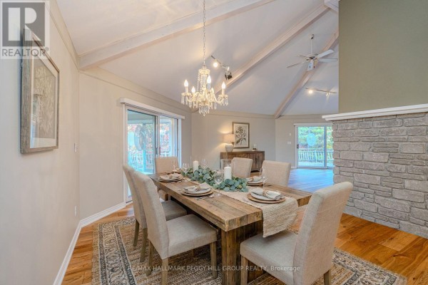 Living room featuring a stone fireplace, vaulted ceiling, and comfortable seating - 1564 Honey Harbour Road, Georgian Bay
