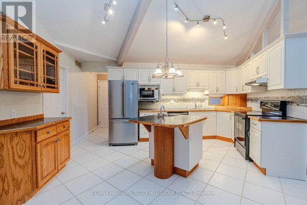 Dining area with wooden table, chandelier, and access to outdoor space - 1564 Honey Harbour Road, Georgian Bay