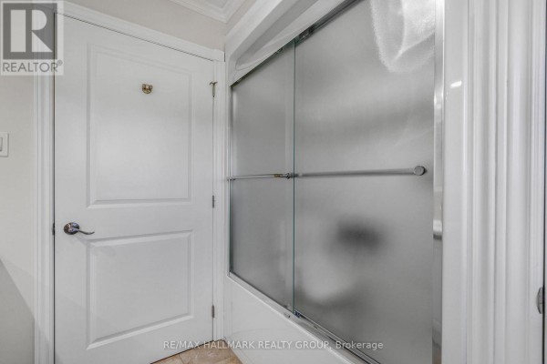 White bathroom door with gold knob next to a frosted glass sliding shower door. - 157 Concession 1 Road, Alfred And Plantagenet