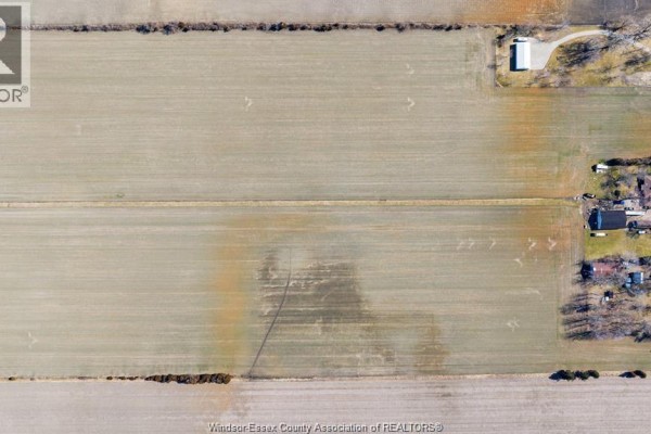 Top-down aerial view of agricultural fields, showcasing farmhouses and property lines with light brown soil. - 157 Road 7, Kingsville