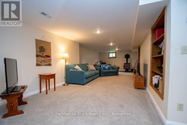 Finished basement living room with sofas and wood stove - 1571 Elm Tree Road Kawartha Lakes