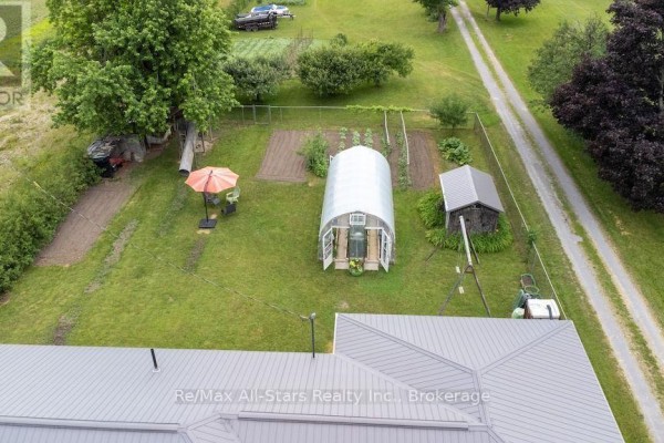 Greenhouse, garden beds, shed, and outdoor seating in yard - 1571 Elm Tree Road Kawartha Lakes