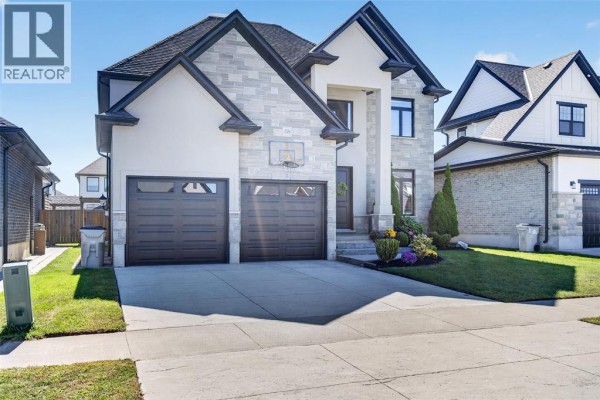 Front exterior view of a modern two-story house with a stone and stucco facade and a three-car garage. - 158 Acton Street, Strathroy