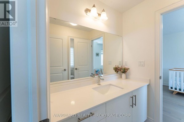 White vanity with a countertop, sink, modern faucet, and a large mirror in a bathroom. - 158 Scarlet Way, Bradford West Gwillimbury