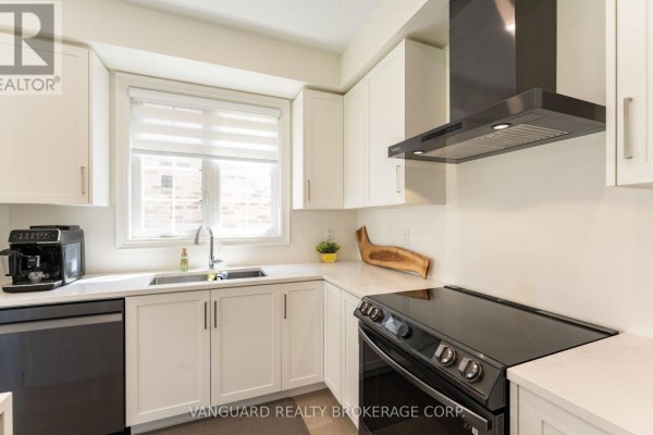 White kitchen with stainless steel appliances, granite countertops, and a window above the sink. - 158 Scarlet Way, Bradford West Gwillimbury