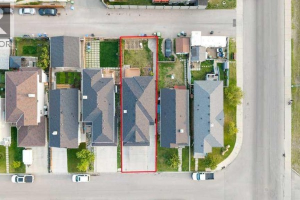 Aerial view of a residential lot with a house, driveway, and fenced backyard highlighted in red. - 158 Taralea Circle Ne, Calgary