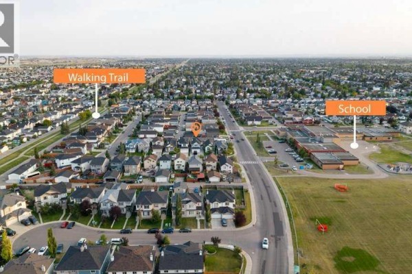 Aerial view showing houses, a school, and a walking trail in a suburban neighborhood. - 158 Taralea Circle Ne, Calgary