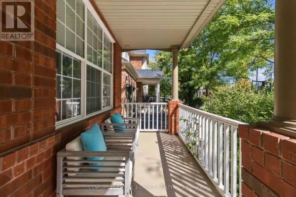 Close-up of the covered front porch with brick pillars and seating. - 1580 Earl Crescent, Milton
