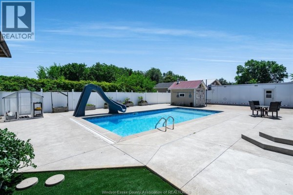 Backyard with a swimming pool, slide, greenhouse, and seating area. - 1582 County Rd 34, Ruthven