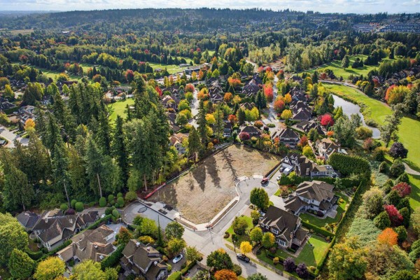 Aerial view of a cleared lot with trees and homes visible in the background. - 15826 36 Avenue, Surrey