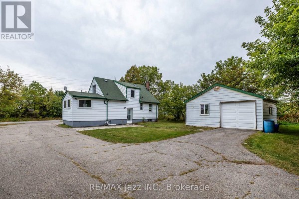 Rear view of the white house and a detached white garage. - 1585 Townline Road N, Clarington
