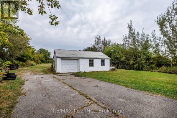 Detached white garage with a white garage door and two windows. - 1585 Townline Road N, Clarington