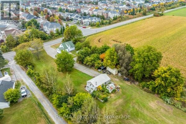 Aerial view of the property surrounded by houses and a cornfield. - 1585 Townline Road N, Clarington