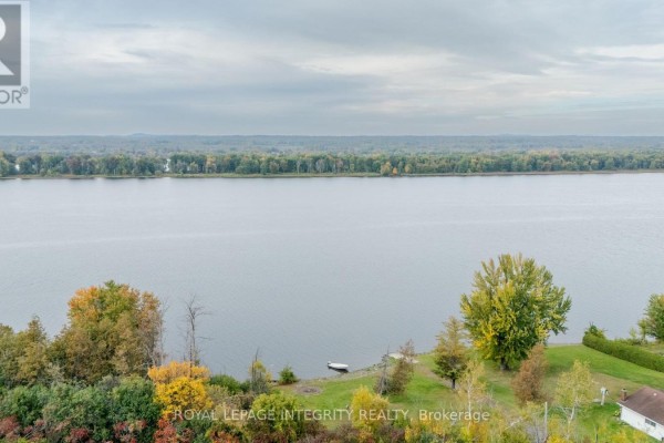 Wide view of a calm river with trees and a few houses. - 1587 Lilac Lane, Ottawa