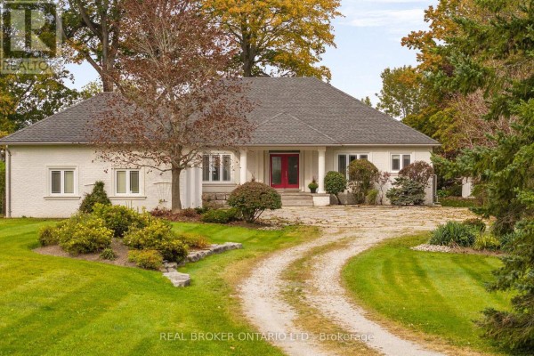 Front view of a white stucco house with a red front door and a paved driveway. - 159 Creighton Street, Ramara