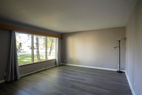 Concrete patio area at the back of the house with a wooden fence. - 159 Larchdale Crescent, Winnipeg