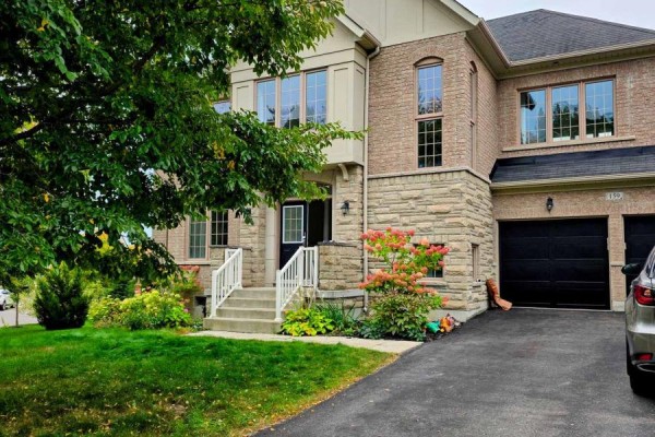 Side view of a brick and stone house at 159 Riding Mountain Drive with a double garage. - 159 Riding Mountain Drive, Richmond Hill