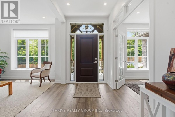 Foyer with dark wood front door, stained glass sidelights, and white walls. - 159 Windermere Road, London North