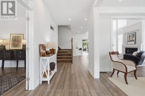 Wide foyer with stairs, a console table, and an armchair. - 159 Windermere Road, London North